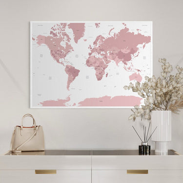 Pink world map poster above chest of drawers