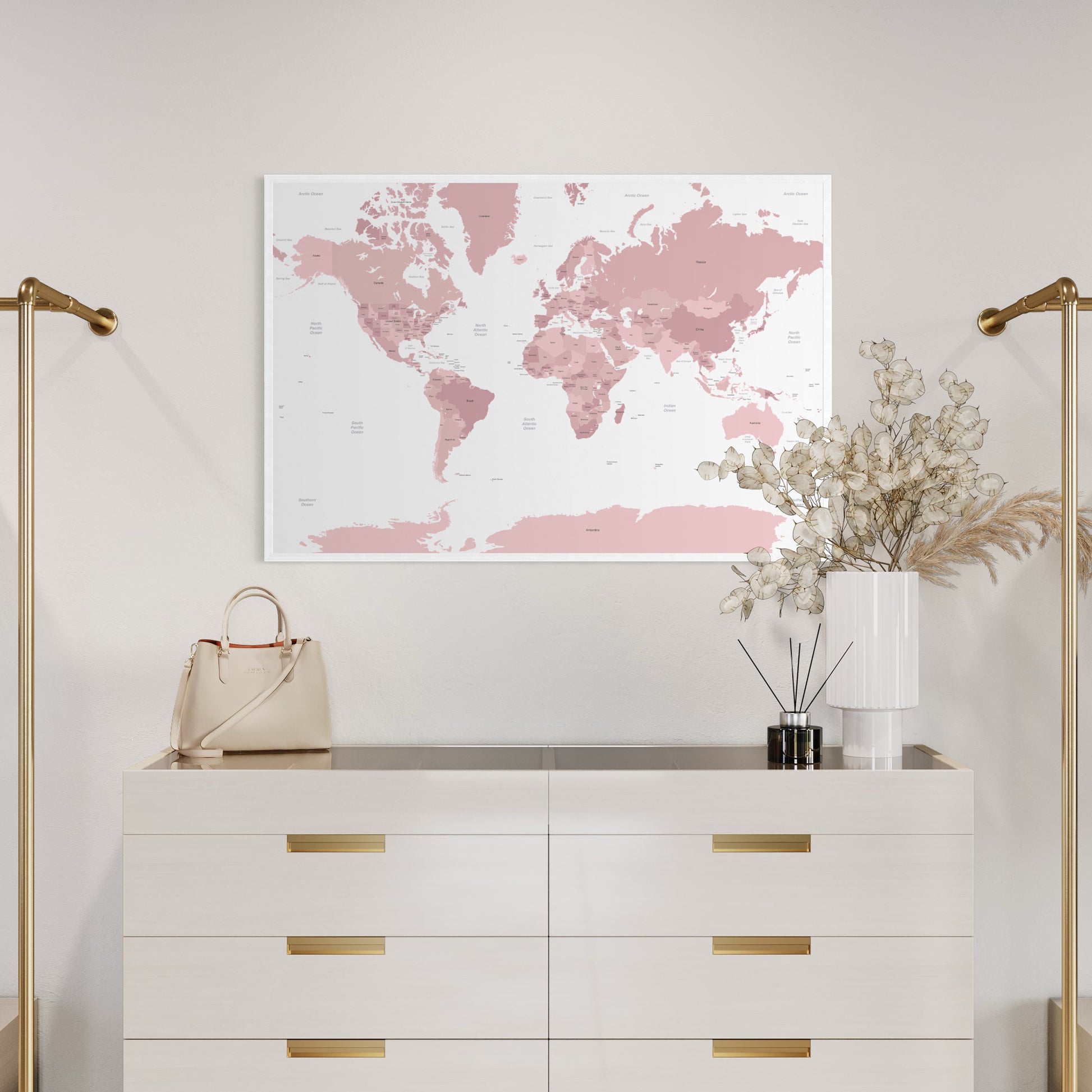 Pink map of the world print poster above chest of drawers